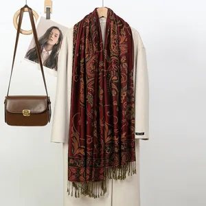 Gros plan d'une écharpe pashmina rouge à motif paisley avec des franges élégantes