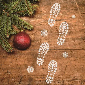 Detail view of Santa Claus footprint and snowflake stencils on vintage wood texture
