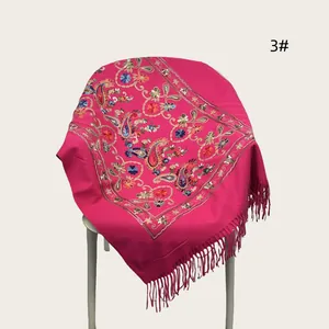 Close-up of elegant magenta shawl featuring intricate floral and paisley embroidery with fringe