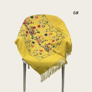 Yellow embroidered floral shawl with elegant tassel fringe shown in detail view