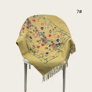 Close-up view of a high-quality floral embroidered cashmere-like shawl with elegant fringe detail