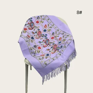 Detailed macro view of a lavender shawl featuring intricate paisley embroidery and fringes