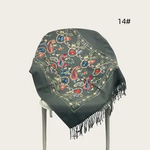 Detail view of ethnic paisley embroidery on heavy grey shawl with tassels
