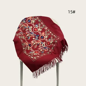 Detailed view of red ethnic style shawl with floral embroidery and tassels
