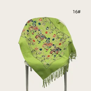 Detailed view of lime green embroidered shawl with elegant floral patterns and fringes