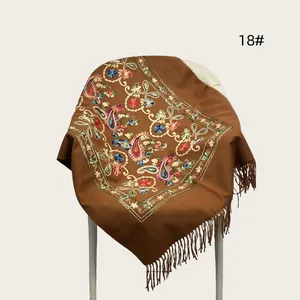Detailed macro view of brown embroidered imitation cashmere shawl with tassels and floral motifs