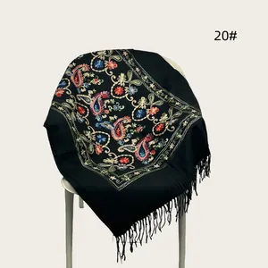 Detailed macro view of black embroidered pashmina shawl featuring floral patterns and tassels