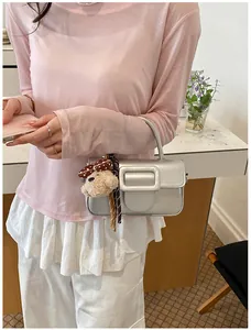 Sac à main élégant en cuir ciré argenté avec grande boucle et breloque chien peluche