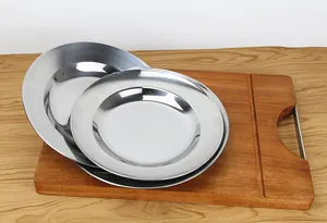 Detail view of premium 410 stainless steel round plates displayed on a wooden board