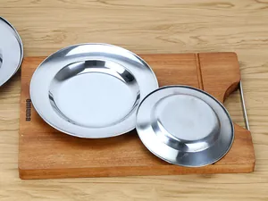 Detailed view of polished stainless steel round plates on a wooden board