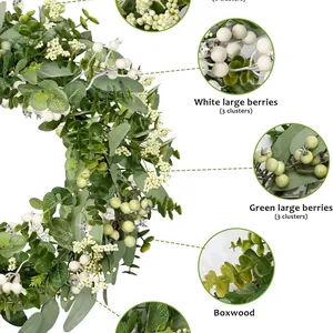 Close-up detail of artificial eucalyptus leaf wreath with white and green berry clusters