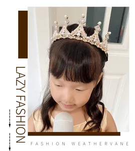 Close-up detail of children's princess crown with pearls and rhinestones on gold alloy