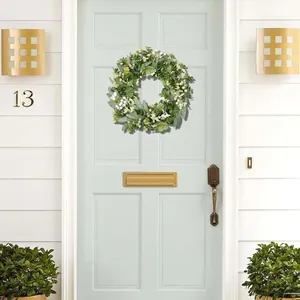 Artificial eucalyptus and berry wreath hanging on a light blue front door for home decor