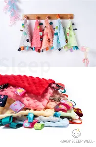 Close-up detail of soft minky dot baby taggy blanket with colorful sensory ribbons