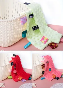 Close-up of soft minky baby security blanket with colorful ribbon tags for infants
