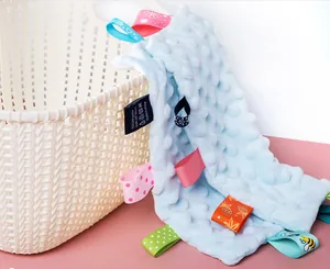 Close-up of baby security blanket with various colorful ribbon tags