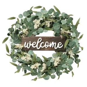 Detailed view of handmade eucalyptus berry wreath with rustic wooden welcome sign