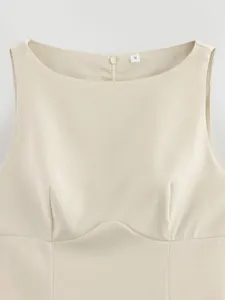 Vista dettagliata di un mini abito beige senza maniche con scollo rotondo e zip posteriore.