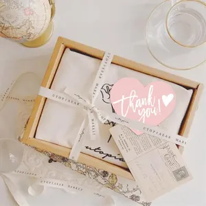 Detail showing a pink heart-shaped card with 'Thank you!' on premium gift packaging