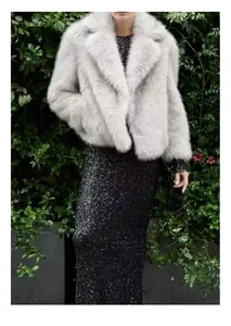 Detailed view of an elegant light gray faux fur coat paired with a black sequin dress