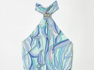 Détail d'une robe imprimée à col licou avec un élégant anneau en métal argenté brillant