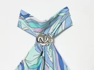 Détail du décolleté dos nu avec anneau métallique sur robe à imprimé bleu