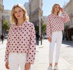 Detail of a pink polka dot jacket with drawstring hem in a city street setting.