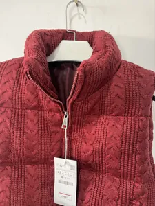 Detail view of burgundy cable-knit padded vest with high collar and silver zipper