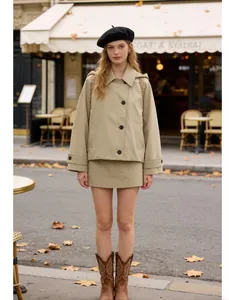 Fashionable khaki hooded cloak-style trench coat and matching mini skirt worn by model in street