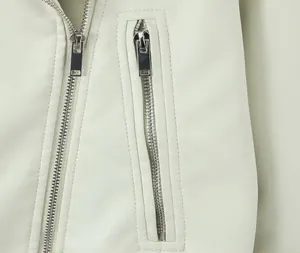 Close-up detail of silver zippers and smooth texture on white PU leather biker jacket