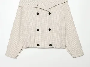 Detailansicht einer karierten Jacke mit Wickelkragen und zweireihiger Knopfleiste für Damen