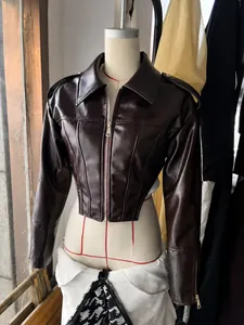 Detailansicht einer glänzenden weinroten Moto-Jacke in bauchfreiem Design auf einer Puppe.