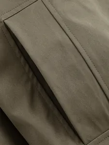 Close-up of durable twill fabric and precision stitching on a women's trench coat detail.