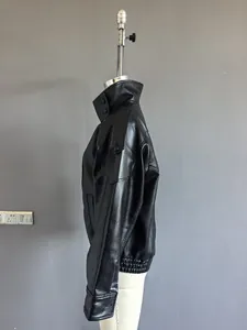 Side view detail of a loose black faux leather jacket for women with shoulder tabs