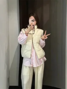 Stylish cream cable knit padded vest worn over a pink shirt in a casual mirror selfie