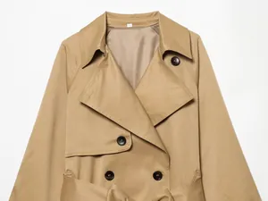 Primer plano de una gabardina corta caqui clásica con solapa ancha y botones