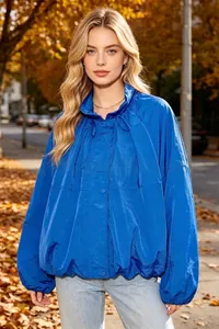 Close-up of a vibrant blue long-sleeved nylon jacket with stand collar and pleats