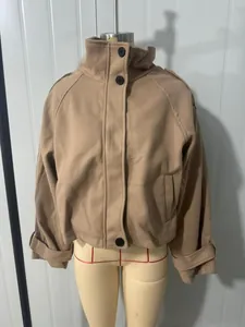 Détail d'une veste d'automne en laine kaki avec col montant sur un mannequin de couture.