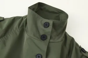 Close-up of high collar and black buttons on an olive green women's short trench coat
