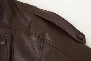 Macro detail view of brown faux leather jacket showing shoulder epaulette and stitching