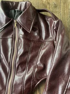 Detailansicht der glänzenden Textur dieser klassischen weinroten Kunstlederjacke