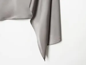 Primer plano de la suave textura de satén gris con elegante diseño de drapeado chal