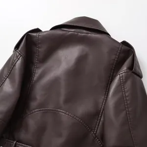 Détail des coutures arrière et de la texture cuir marron d'une veste de motard vintage.