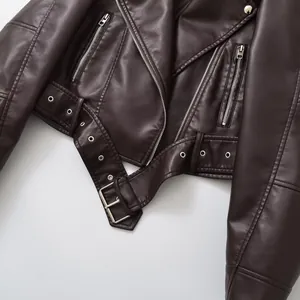 Gros plan d'un blouson de motard en cuir marron montrant les détails de la boucle et du zip