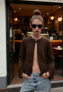 Stylish brown knit cardigan with fringe trim detail worn by model in cafe setting