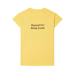 Vista detallada del texto impreso 'Banned For Being Iconic' en una camiseta casual amarilla