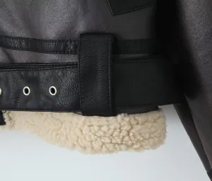 Gros plan d'une veste biker en similicuir avec ceinture, oeillets et doublure en peau