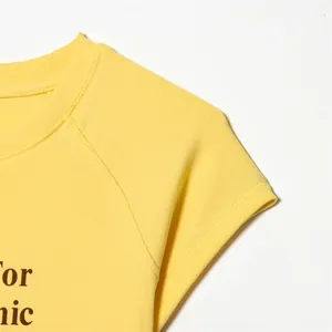 Vista macro detallada de una camiseta de algodón amarillo con cuello redondo y costuras
