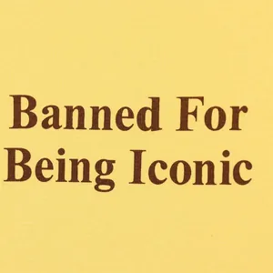 Primer plano detallado del estampado marrón 'Banned For Being Iconic' en camiseta amarilla