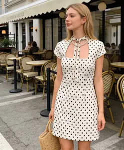 Détail de robe courte à pois avec col à nœud papillon et découpe